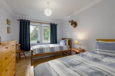 a bedroom with two beds and a window at Scenic Oaklodge with wood burner in Saint Fillans
