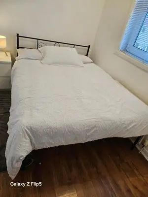 a bedroom with a bed with white sheets and a window at Double room available in Livingston