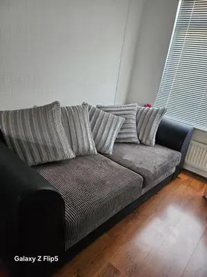 a black couch in a living room with two pillows at Double room available in Livingston