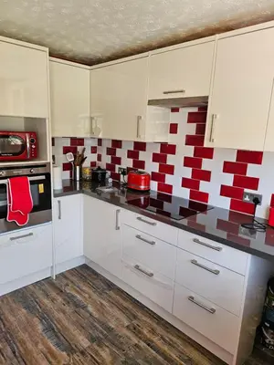 a kitchen with white cabinets and red and white tiles at Double room available in Livingston
