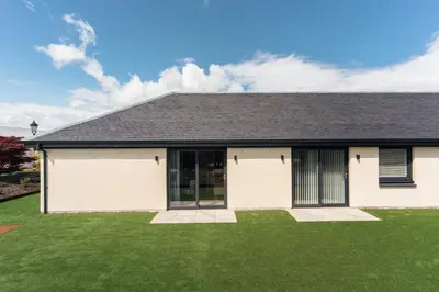 a house with a green lawn at Jackton Distillery Steadings in Busby