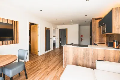 a kitchen and living room with a table and a counter at Jackton Distillery Steadings in Busby