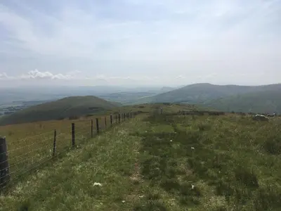 a fence on top of a hill with mountains at Garden Retreat in Nine Mile Burn