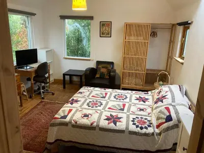 a bedroom with a bed with a quilt on it at Garden Retreat in Nine Mile Burn