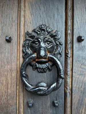 a bronze door knocker of a lion with a pipe in its mouth at The Hidden Mill, Historic Beauty Spot and spa in Castle Douglas
