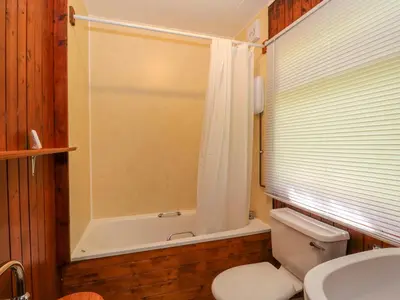 a bathroom with a toilet and a tub and a sink at Lodge 2 - 