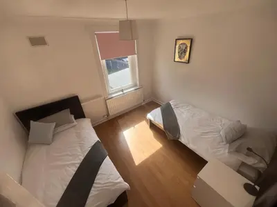 a bedroom with two beds and a window at Mitchell House in Bellshill