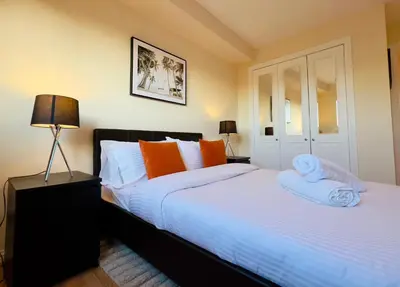 a bedroom with two beds with orange and white pillows at Sleek & Modern 2BR - Easy Access to City Centre in Glasgow