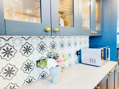 a kitchen with blue cabinets and a vase of flowers at Top Floor Apartment with Castle Views in Edinburgh