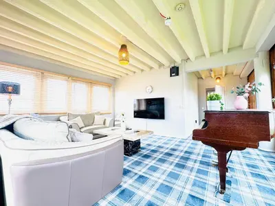 a living room with a couch and a piano at Top Floor Apartment with Castle Views in Edinburgh