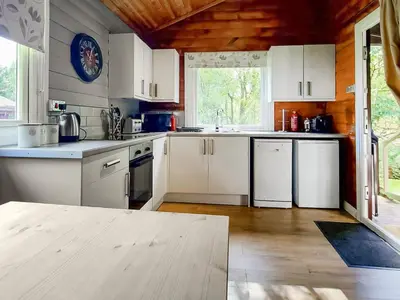 a kitchen with white appliances and a wooden ceiling at Grouse Lodge in Dunoon