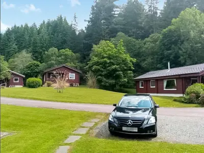a car parked in the driveway of a house at Grouse Lodge in Dunoon