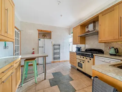 a kitchen with wooden cabinets and a green stool in it at Torland in Dalserf