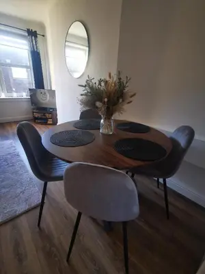 a dining room table with chairs and a vase of flowers at Blanca apartment - free parking! in Oban