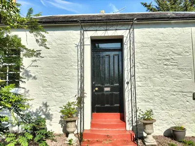 a white house with a black door and red stairs at Park Cottage - Spacious & Luxurious Room in B Listed Cottage in Moffat