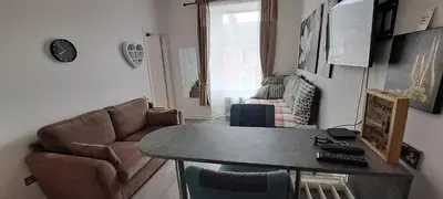 a living room with a couch and a table at Cozy, modern flat in Govan in Glasgow