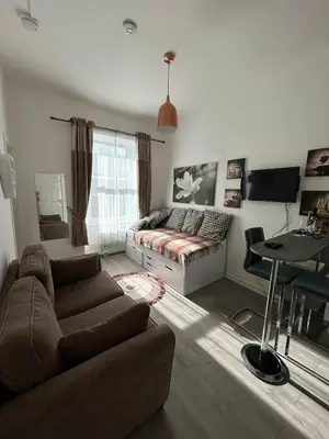 a living room with a couch and a table at Cozy, modern flat in Govan in Glasgow
