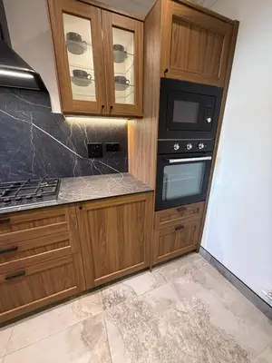 a kitchen with wooden cabinets and a stove top oven at Home away from home in Glasgow - Free Street Parking in Mansewood