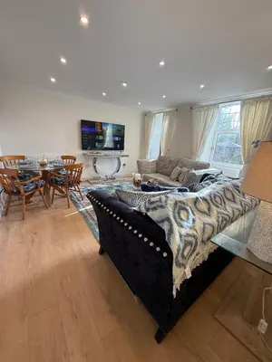a living room with a couch and a dining room at Home away from home in Glasgow - Free Street Parking in Mansewood