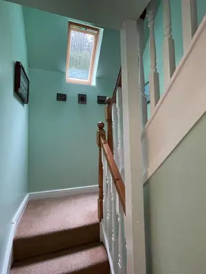 a staircase with blue walls and a window at Cosy Karibu cottage with stunning canal views in Cairnbaan