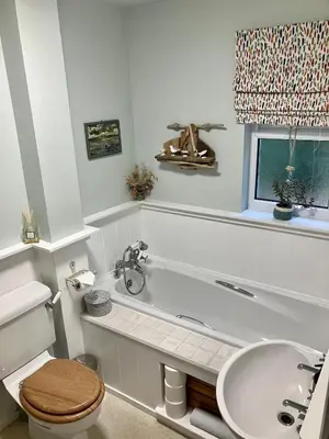 a bathroom with a tub and a toilet and a sink at Cosy Karibu cottage with stunning canal views in Cairnbaan