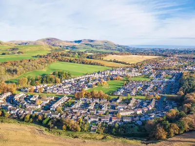 an aerial view of a village in the hills at Woodland Pod in Leadburn