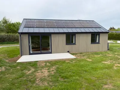 a small house with solar panels on the roof at Loganlea Lodge in Loanhead