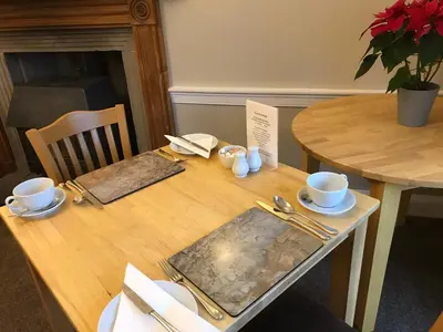 a wooden table with cups and saucers on it at West Plean House in Stirling