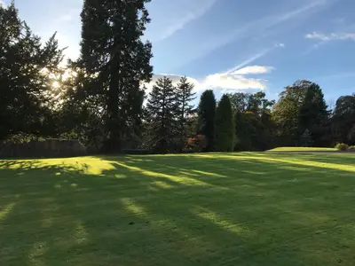 a large green field with trees in the background at West Plean House in Stirling