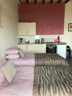 a bedroom with a bed and a kitchen in it at The Shorehouse in Brodick
