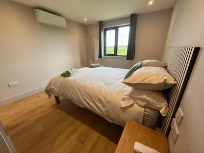 a bedroom with a bed and a window at Threipmuir Lodge in Loanhead
