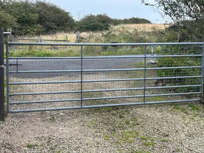 a metal gate on the side of a road at Sanda View, Isle of Arran in Sliddery