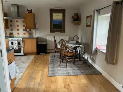 a dining room with a table and chairs in a kitchen at Sanda View, Isle of Arran in Sliddery