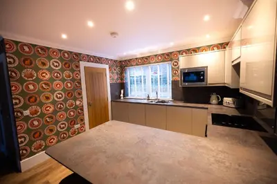 a large kitchen with a counter top and a window at Bracken Lodge in Comrie