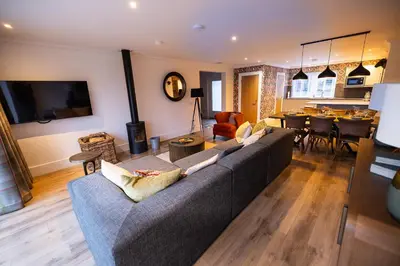 a living room with a couch and a dining room at Bracken Lodge in Comrie