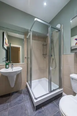 a bathroom with a shower and a toilet and a sink at The Cobbled Rider in Edinburgh