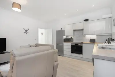 a white kitchen with a couch and a table at Coaledge Coorie - A wee find in Fife in Fordell