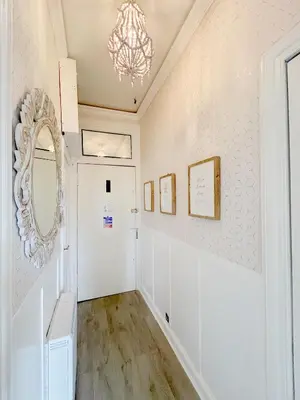 a hallway with a white door and a mirror at Chic flat close to Edinburgh, Airport, & Zoo in Edinburgh