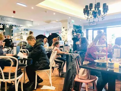 a group of people sitting at tables in a restaurant at Chic flat close to Edinburgh, Airport, & Zoo in Edinburgh