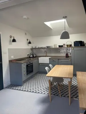 a kitchen with gray cabinets and a wooden table at The Muse in Edinburgh