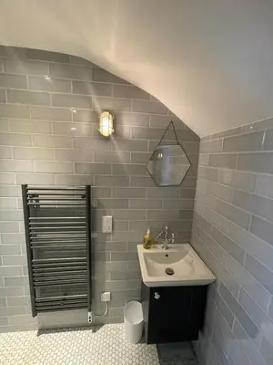 a bathroom with a sink and blue tile walls at The Muse in Edinburgh