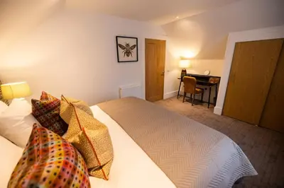 a bedroom with a bed and a desk in a room at Heather Lodge in Comrie