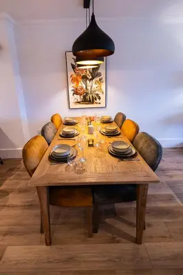 a dining room table with chairs and aendant light at Heather Lodge in Comrie