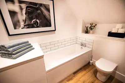 a bathroom with a bath tub and a toilet at Thistle Lodge in Comrie