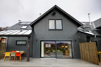 a black house with a table and chairs at Thistle Lodge in Comrie