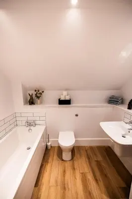 a bathroom with a tub and a toilet and a sink at Thistle Lodge in Comrie