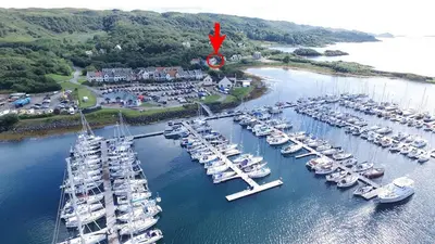 a bunch of boats are docked in a harbor at Craobh Haven Cottages in Craobh Haven