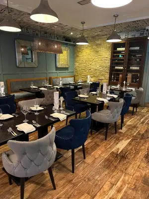 a restaurant with black tables and blue chairs at The Tudor Hotel in Airdrie