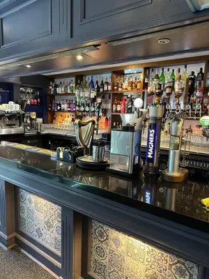 a bar with a lot of bottles of alcohol at The Tudor Hotel in Airdrie