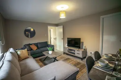 a living room with a couch and a tv at Bonnie Apartment in Coatbridge
